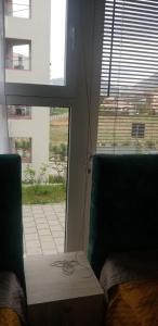 een kamer met 2 groene stoelen en een raam bij J & A in Tirana