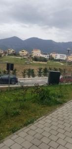 een hek naast een veld met huizen en een weg bij J & A in Tirana