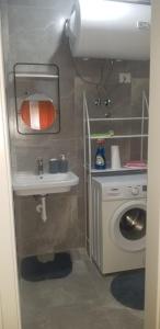 een badkamer met een wastafel en een wasmachine bij J & A in Tirana