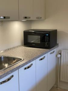 eine Küche mit Mikrowelle und Spüle in der Unterkunft VS-Guesthouse in Kopenhagen
