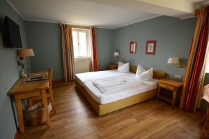 a bedroom with a large white bed and a table at Landhotel Schloss Buttenheim in Buttenheim