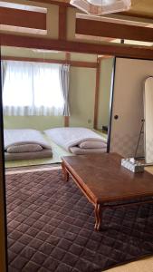 a large bedroom with two beds and a mirror at SIBARIAN Guest House in Kaga