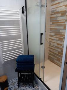 una ducha con una toalla azul en un taburete en el baño en Maison 100m de la plage les pieds dans l'eau, en Surtainville