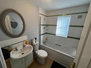 Modern 3 Bedroom House Close to Liverpool Centre في West Derby: حمام مع حوض وحوض استحمام ومرحاض ومغسلة