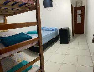 Camera con 2 letti a castello e una TV di Oceano Suítes ad Arraial do Cabo