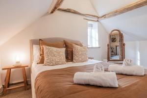 una camera da letto con un grande letto con asciugamani di The Gamekeeper's Cottage - Stunning 2 Bed! a Leafield