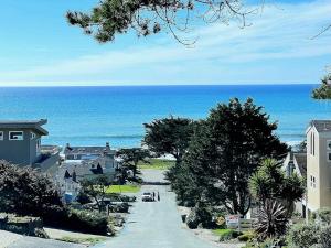 a road leading to the ocean with houses and trees at 555 Lancaster St. in Cambria