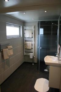 ein Bad mit einer Dusche und einem Waschbecken in der Unterkunft Ferienwohnung Småland ausserhalb Älmhult in Diö