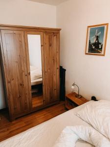- une chambre avec une grande armoire en bois à côté d'un lit dans l'établissement Ferienwohnung Am Leuchtturm, à Schausende