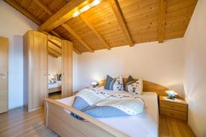 - une chambre avec un lit et un plafond en bois dans l'établissement Schnatzhof Apartment Schwalbennest, à Naturno
