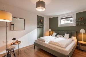 a bedroom with a large bed with white sheets at Das Karl Appartement in Söll