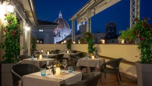 フィレンツェにあるB&B Hotel Firenze Laurus Al Duomoの夜のテーブルと椅子付きのレストラン