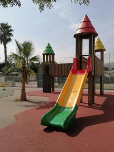 une aire de jeux avec toboggan coloré dans un parc dans l'établissement MOBILHOME COSY SPACIEUX 42m2, CLIMATISE, TV & LL, 3 chambres, à Vic-la-Gardiole
