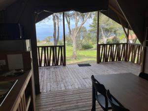 a porch with a table and chairs on a deck at lodge lavallee in Belvédère