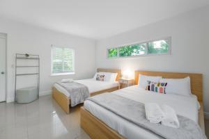 um quarto com 2 camas e 2 janelas em Discover Serenity in this Tranquil Miami Home em Miami