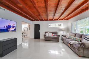 uma sala de estar com um sofá e uma televisão de ecrã plano em Discover Serenity in this Tranquil Miami Home em Miami