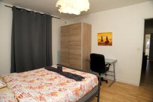 1 dormitorio con cama, escritorio y silla en Appartement Sympa entre Paris et Disneyland, en Noisy-le-Grand