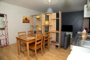 a dining room with a table and chairs and a kitchen at Appartement Sympa entre Paris et Disneyland in Noisy-le-Grand
