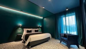 NOLA BOUTIQUE HOTEL - self check- في نولا: غرفة نوم خضراء بسرير وكرسي