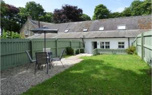 a patio with a table and an umbrella in a yard at Weavers Cottage in Haverfordwest