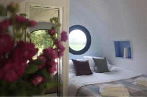 a bedroom with a bed with a mirror and pink flowers at The Heron's Tree in Llandovery