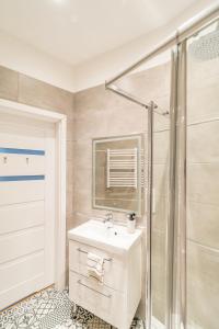 uma casa de banho com um lavatório e um chuveiro em Starowiślna Apartment - Balcony, Top Location, Tram & Train Nearby - by Rentujemy em Cracóvia