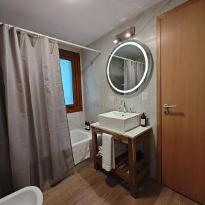 a bathroom with a sink and a mirror and a tub at ANFITEATRO APARTS & LOFTS in San Carlos de Bariloche +70 photos