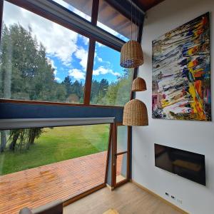 a living room with a large window and a fireplace at ANFITEATRO APARTS & LOFTS in San Carlos de Bariloche