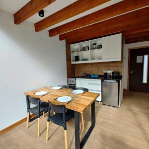 cocina con mesa de madera y algunas sillas en ANFITEATRO APARTS & LOFTS en San Carlos de Bariloche