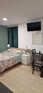 1 dormitorio con cama, escritorio y silla en Turísticos Cuenca 3, en Madrid