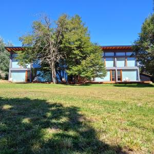 a house with a large yard in front of it at ANFITEATRO APARTS & LOFTS in San Carlos de Bariloche