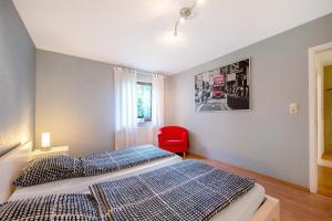 een slaapkamer met een bed en een rode stoel bij Elversberg in Spiesen-Elversberg