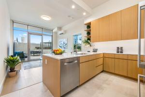 a kitchen with wooden cabinets and stainless steel appliances at Sky Ala Moana 809 condo in Honolulu