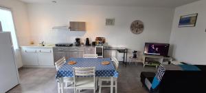 a kitchen with a table and chairs in a room at Maison Sabline 3 - T2 avec terrasse et parking 700m de l'océan - bébé bienvenu in Yves