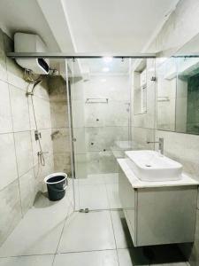 a bathroom with a glass shower and a sink at Dream Pent House in Hyderabad