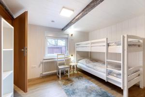 a bedroom with two bunk beds and a table at Urlaub an der Elbmündung in Neuenkirchen