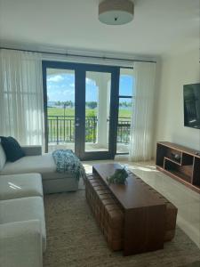 a living room with a couch and a coffee table at The Country Club Residences at Grand Reserve in Rio Grande