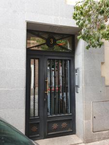 una puerta negra con una ventana en un edificio en Turísticos Cuenca 3, en Madrid