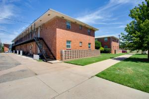 um edifício de tijolos vermelhos com uma escada em frente em Walkable OSU Apartment - 6 Blocks to Stadium! em Stillwater