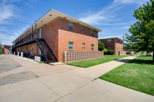 a red brick building with a staircase in front of it at Walkable OSU Apartment - 6 Blocks to Stadium! in Stillwater