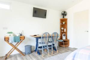 惠斯塔布的住宿－Pear Tree Cabin，配有桌子和两把椅子以及电视的房间