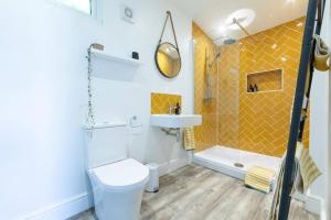 a bathroom with a toilet and a sink and a shower at Pear Tree Cabin in Whitstable