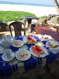 una mesa azul y blanca con platos de comida. en Sea Garden Beach Resort, en Habaraduwa Central