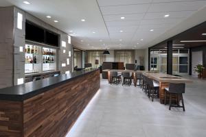 a lobby with a bar and tables and chairs at Courtyard by Marriott Jackson Madison in Madison