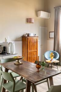 a kitchen with a wooden table and green chairs at Residenza Della Signoria in Florence