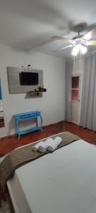 a bedroom with a bed and a tv on the wall at Pousada Namaste in Casa Branca