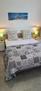1 dormitorio con 1 cama con edredón en Maison T2 avec terrasse 700m de l'océan aux BOUCHOLEURS- En été location vendredi à vendredi en Yves