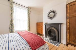 a bedroom with a bed and a fireplace at Painter Cottage in Whitstable