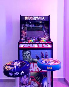 a star wars pinball machine with two stools at Hotel Porto in Gandía