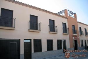 - un grand bâtiment blanc avec des portes et des fenêtres noires dans l'établissement Hospedería Laredo, à La Carlota